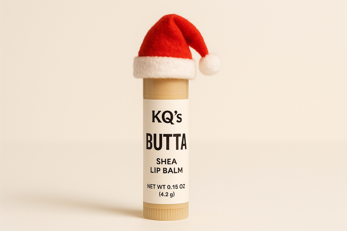 tube of KQs BUTTAs just shea lip balm with a christmas hat on top